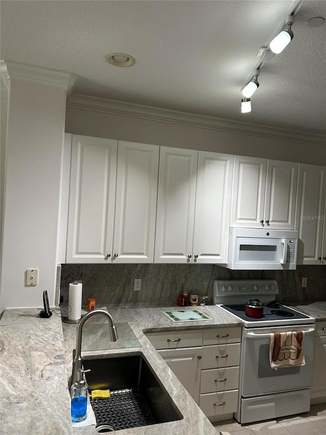 kitchen with tasteful backsplash, white appliances, white cabinetry, and a sink