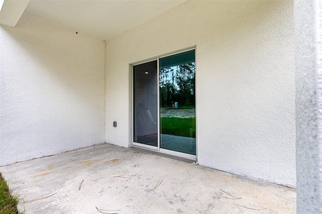 doorway to property with stucco siding and a patio