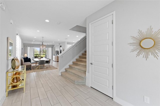 entrance foyer featuring stairs, recessed lighting, a chandelier, and wood finish floors