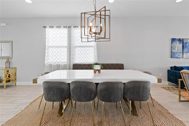 dining room featuring a notable chandelier, baseboards, and wood tiled floor