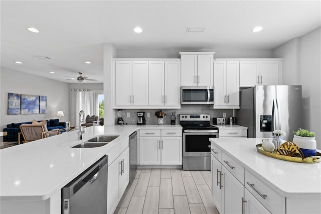 kitchen featuring a sink, backsplash, appliances with stainless steel finishes, and light countertops