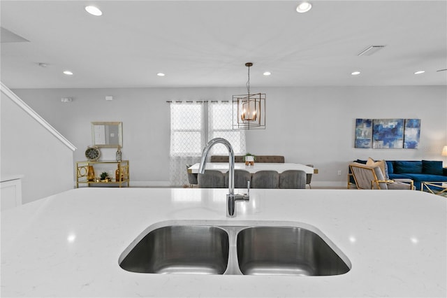kitchen with visible vents, open floor plan, recessed lighting, hanging light fixtures, and a sink