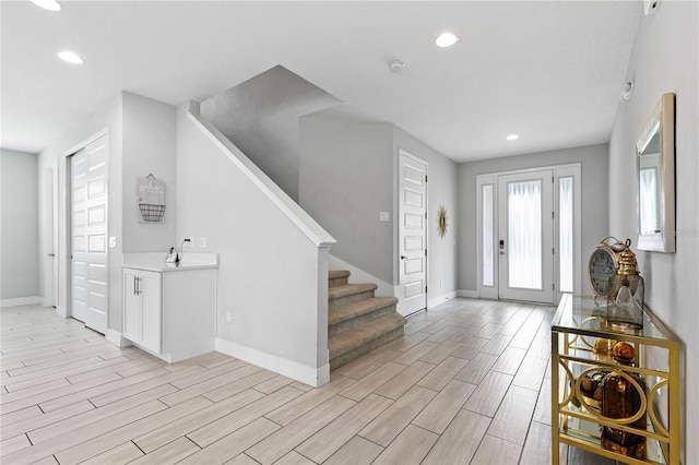 entryway with stairway, recessed lighting, baseboards, and wood tiled floor