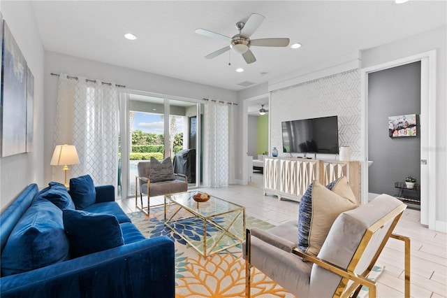 living area with a ceiling fan, baseboards, light wood finished floors, recessed lighting, and an accent wall
