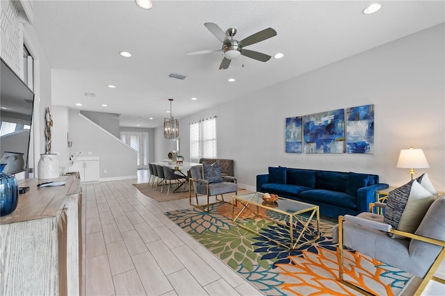 living area featuring baseboards, visible vents, wood finish floors, recessed lighting, and ceiling fan with notable chandelier