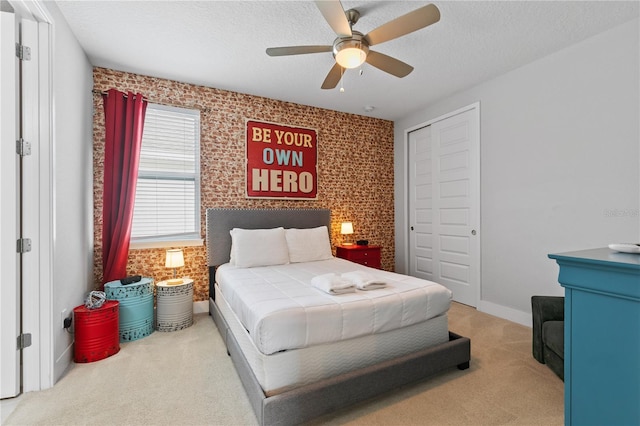carpeted bedroom with a ceiling fan, baseboards, a closet, and a textured ceiling