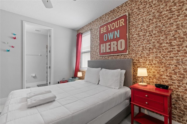 bedroom with a textured ceiling, brick wall, and a ceiling fan