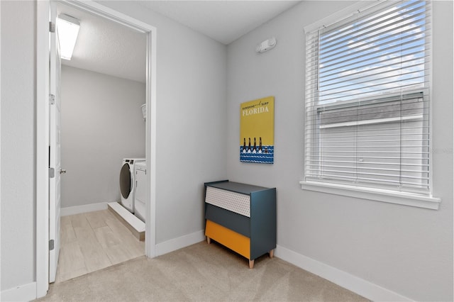 washroom with baseboards, light colored carpet, independent washer and dryer, and laundry area