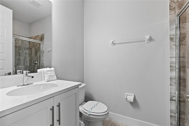 full bath featuring visible vents, toilet, a shower stall, baseboards, and vanity