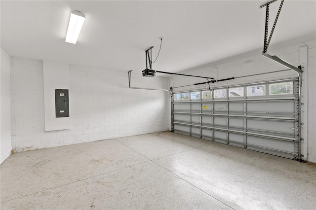 garage with concrete block wall, electric panel, and a garage door opener