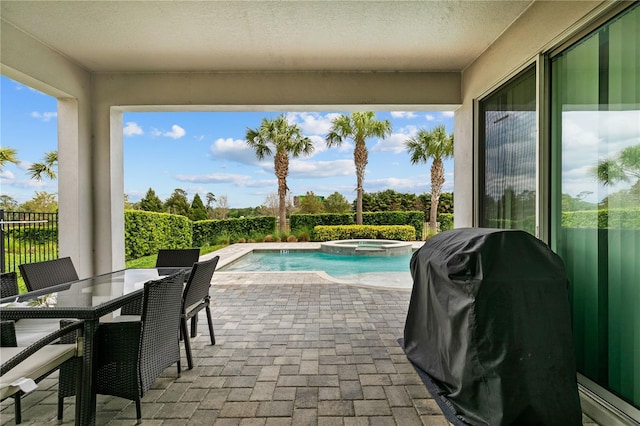 view of swimming pool with grilling area, a pool with connected hot tub, fence, outdoor dining space, and a patio