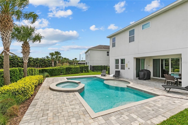 view of pool featuring a patio, fence, and a pool with connected hot tub