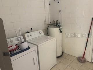 washroom with gas water heater, light tile patterned floors, and separate washer and dryer