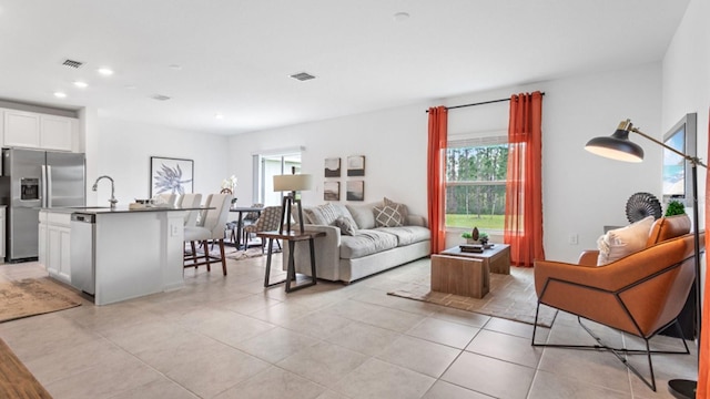 living area with recessed lighting, visible vents, and light tile patterned floors