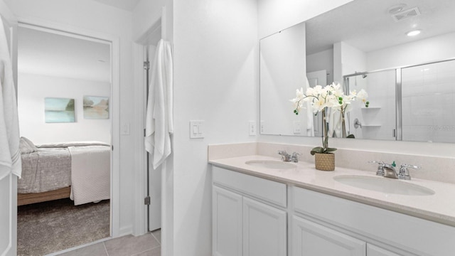 ensuite bathroom with tile patterned flooring, a stall shower, ensuite bath, and a sink