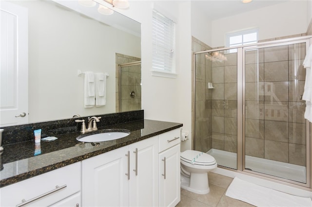 7463 Marker Ave, Kissimmee, FL 34747 - bathroom with tile patterned flooring, a shower stall, toilet, and vanity