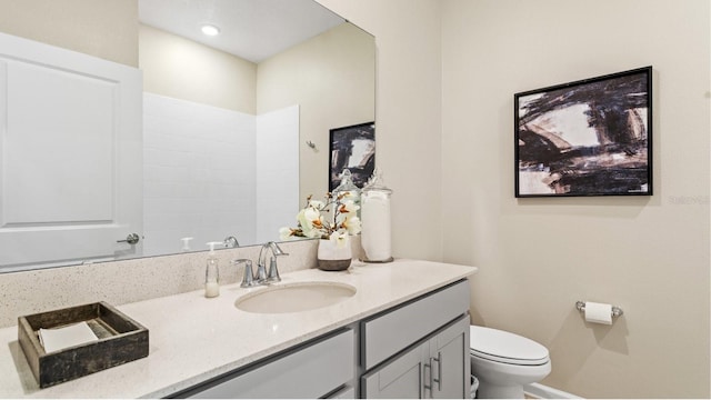 full bathroom with toilet, vanity, and baseboards