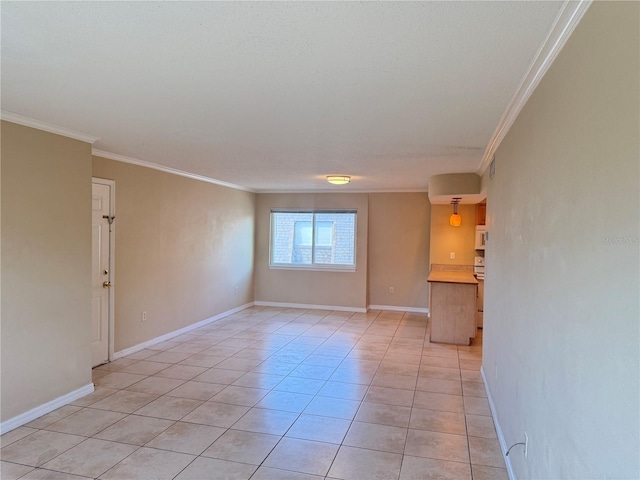 spare room featuring light tile patterned floors, baseboards, and ornamental molding