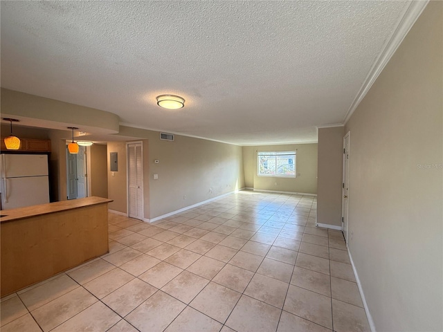 unfurnished living room with baseboards, visible vents, light tile patterned flooring, a textured ceiling, and crown molding