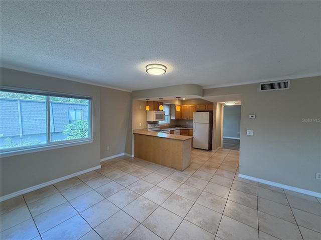 kitchen with white appliances, light tile patterned floors, visible vents, a peninsula, and ornamental molding