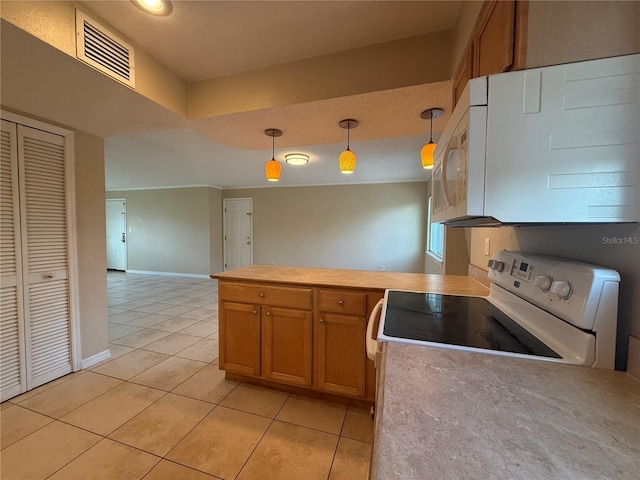 kitchen featuring white appliances, brown cabinetry, visible vents, a peninsula, and light tile patterned flooring