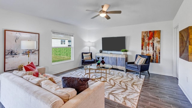 living area with baseboards, ceiling fan, and wood tiled floor