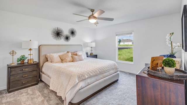 bedroom featuring baseboards, light colored carpet, and ceiling fan