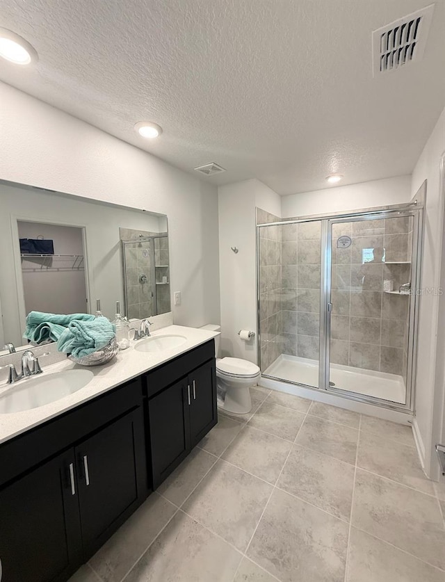 945 Laurel View Way, Groveland, FL 34736 - full bath featuring double vanity, a stall shower, a spacious closet, a textured ceiling, and tile patterned floors