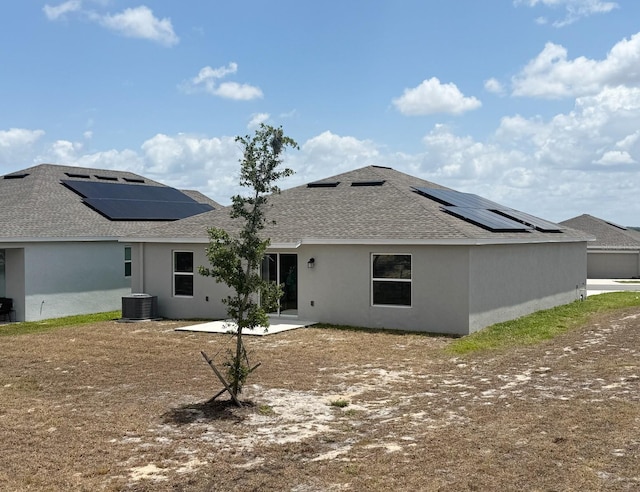 945 Laurel View Way, Groveland, FL 34736 - back of house featuring solar panels, a shingled roof, and stucco siding