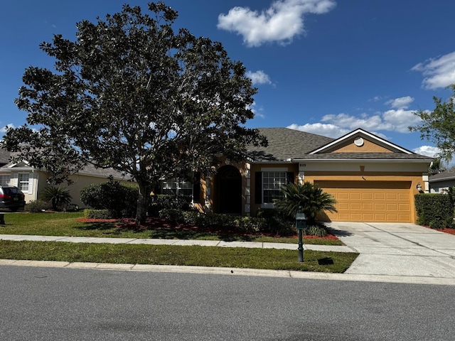 view of front facade with concrete driveway, a garage, and stucco siding