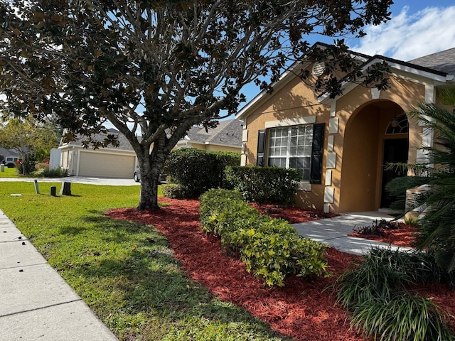 view of front of property featuring a garage, stucco siding, an outdoor structure, and a front lawn