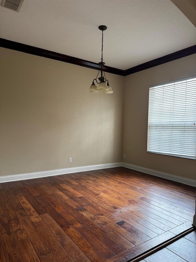 empty room with visible vents, baseboards, ornamental molding, and dark wood-style flooring