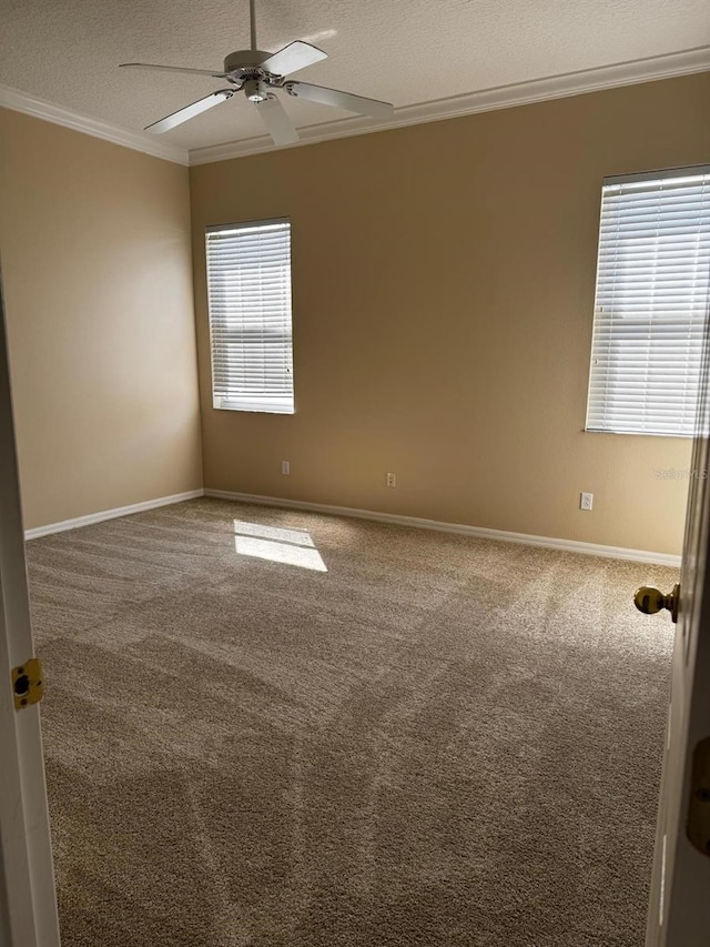 unfurnished room with ornamental molding, a textured ceiling, carpet flooring, baseboards, and ceiling fan