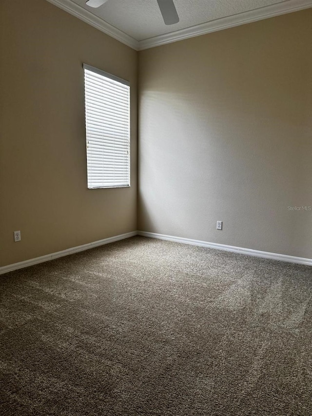 carpeted empty room with ceiling fan, a textured ceiling, baseboards, and ornamental molding