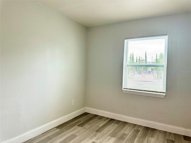 unfurnished room featuring light wood-type flooring and baseboards