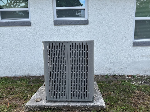 exterior details featuring central AC and stucco siding