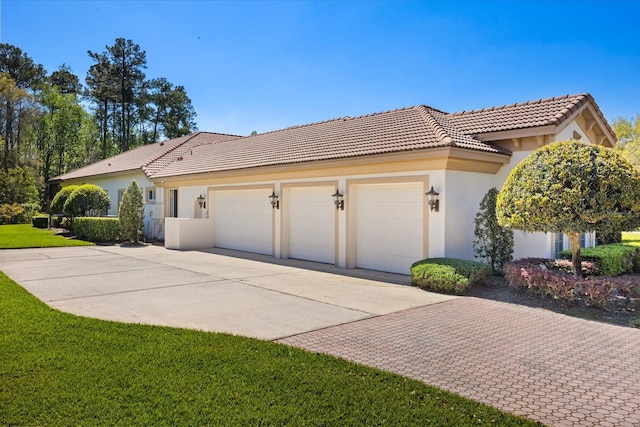 view of home's exterior with stucco siding, a tiled roof, concrete driveway, and a garage