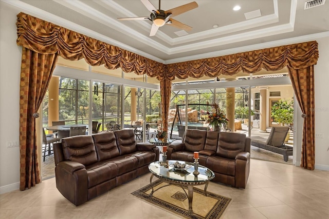 tiled living area with visible vents, a ceiling fan, baseboards, crown molding, and a raised ceiling