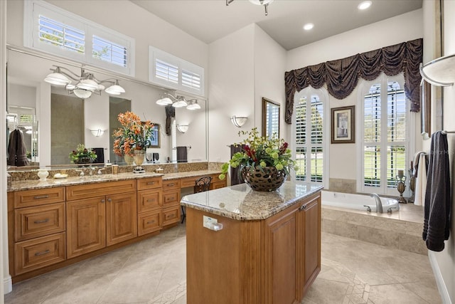 bathroom with recessed lighting, a healthy amount of sunlight, vanity, and a garden tub