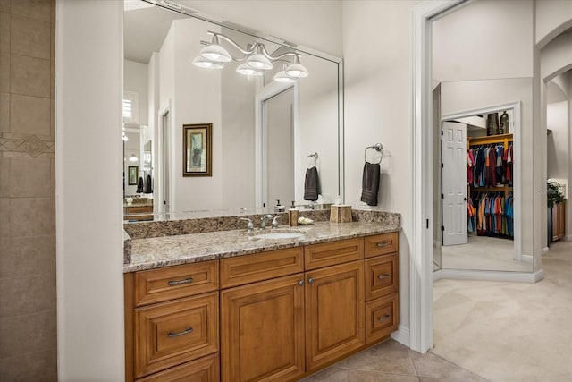 full bath with vanity, baseboards, and tile patterned flooring