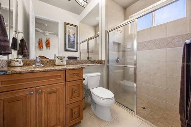 full bathroom featuring a shower stall, ceiling fan, toilet, tile patterned floors, and vanity