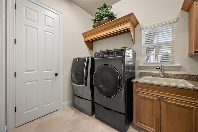 laundry area with a sink, independent washer and dryer, and light tile patterned floors