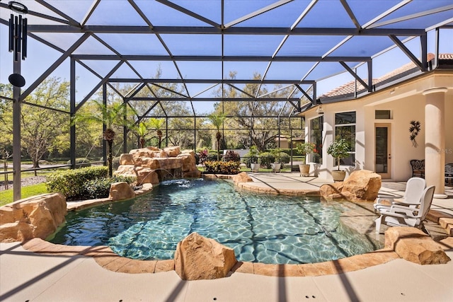 outdoor pool featuring glass enclosure and a patio