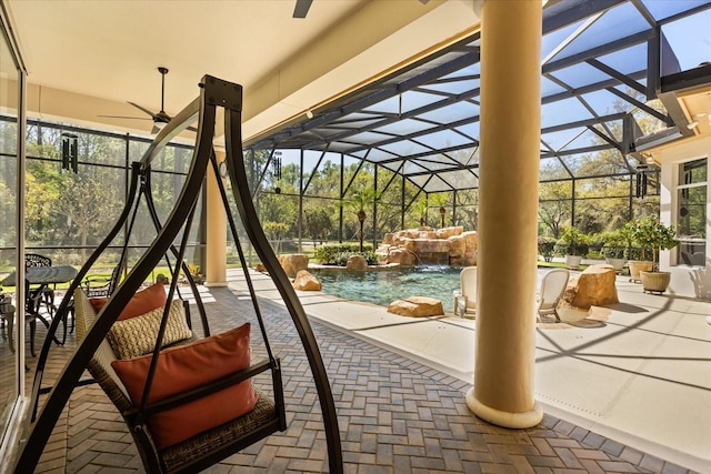 view of play area with glass enclosure, a patio, a ceiling fan, and an outdoor pool