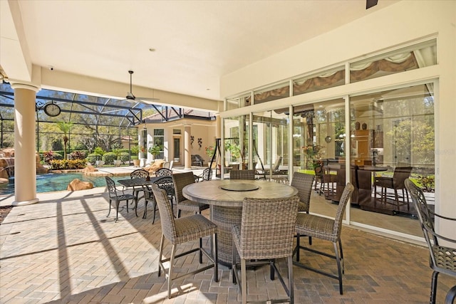 view of patio featuring glass enclosure, outdoor dining area, and an outdoor pool