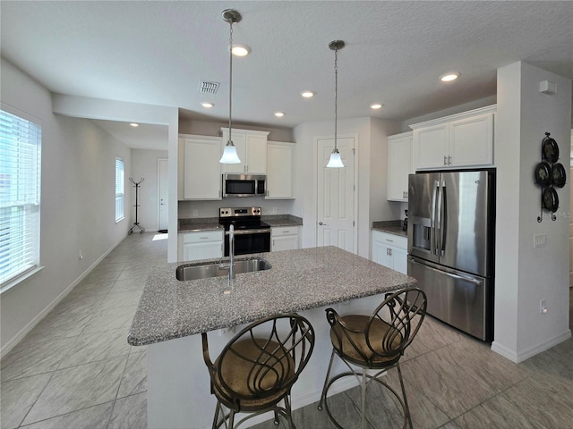 kitchen with visible vents, appliances with stainless steel finishes, a breakfast bar, and a sink