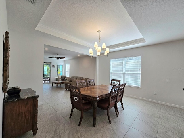 dining space with baseboards, a raised ceiling, a notable chandelier, and a textured ceiling