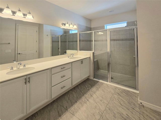 bathroom with a sink, marble finish floor, a stall shower, and double vanity