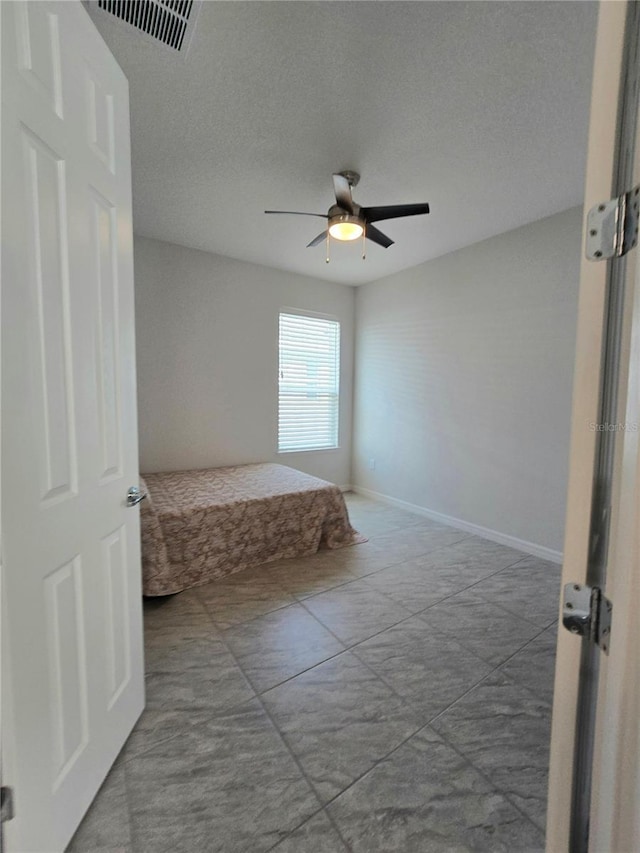 unfurnished bedroom with baseboards, visible vents, and ceiling fan