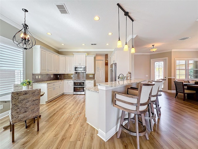 kitchen featuring visible vents, tasteful backsplash, appliances with stainless steel finishes, and white cabinetry